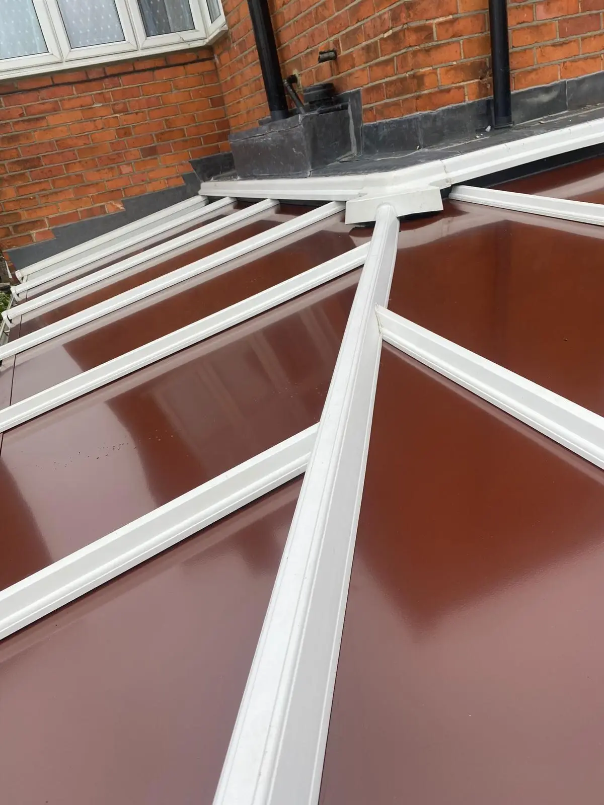Close view of a brown insulated panel conservatory roof with white glazing bars