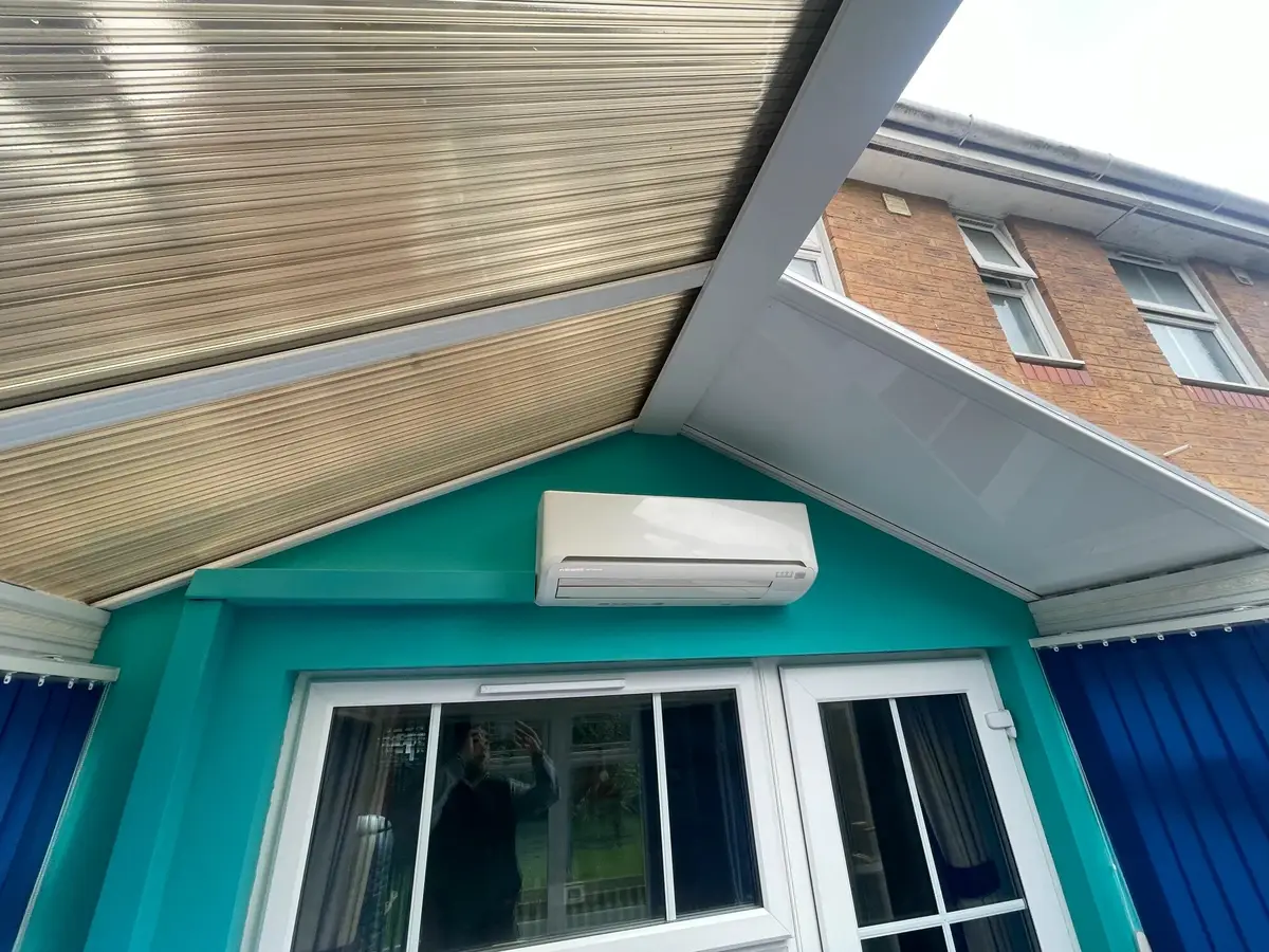 Conservatory roof part way through replacement, with old polycarbonate sheets above the doors and new panels alongside