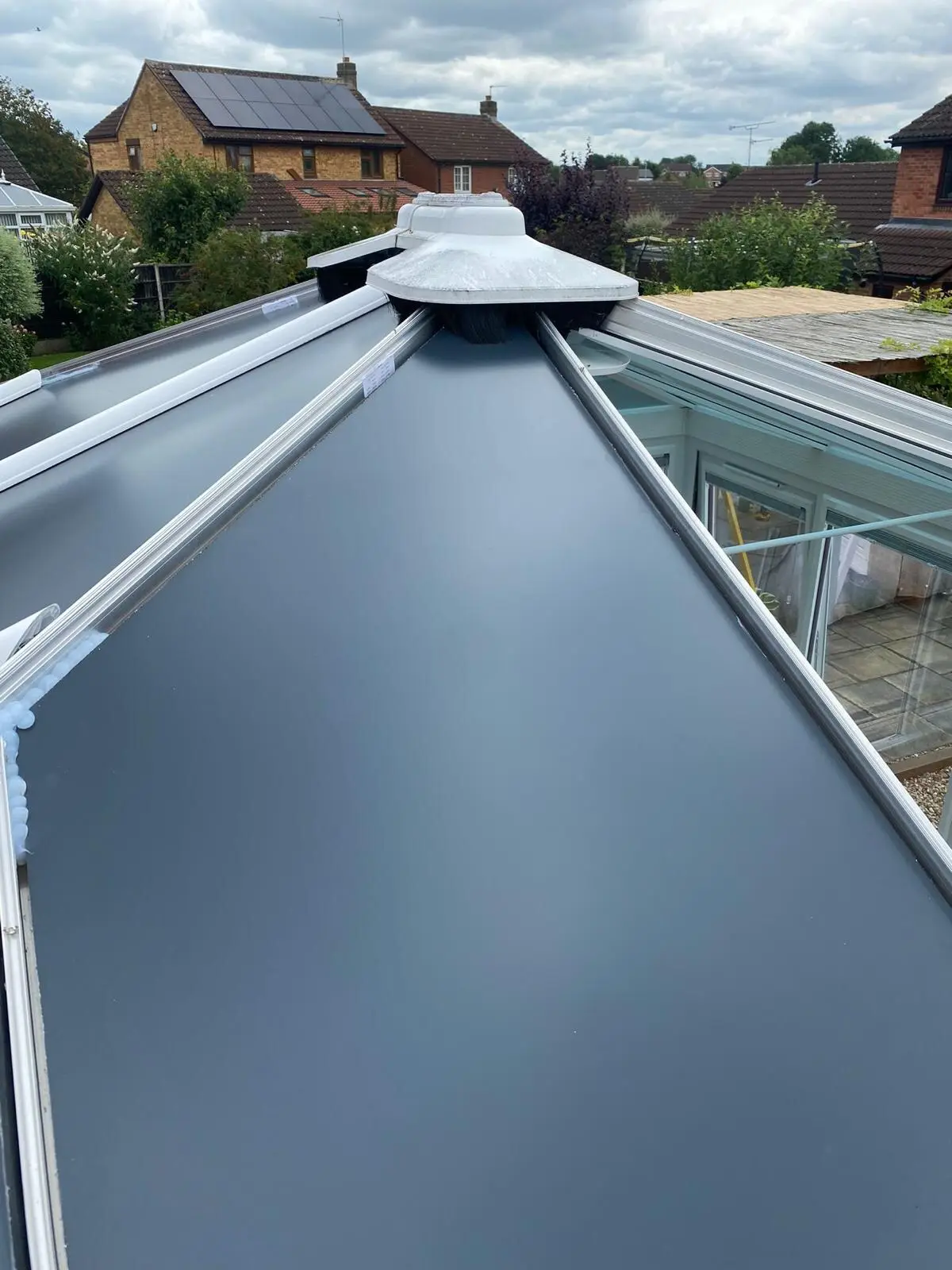 Anthracite grey insulated roof panels fitted up to the central hub of a conservatory