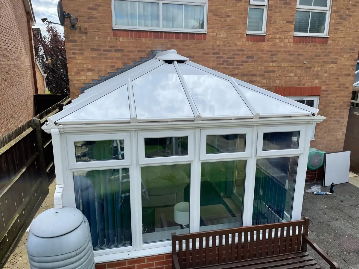 Front view of a hipped conservatory roof finished in white insulated panels