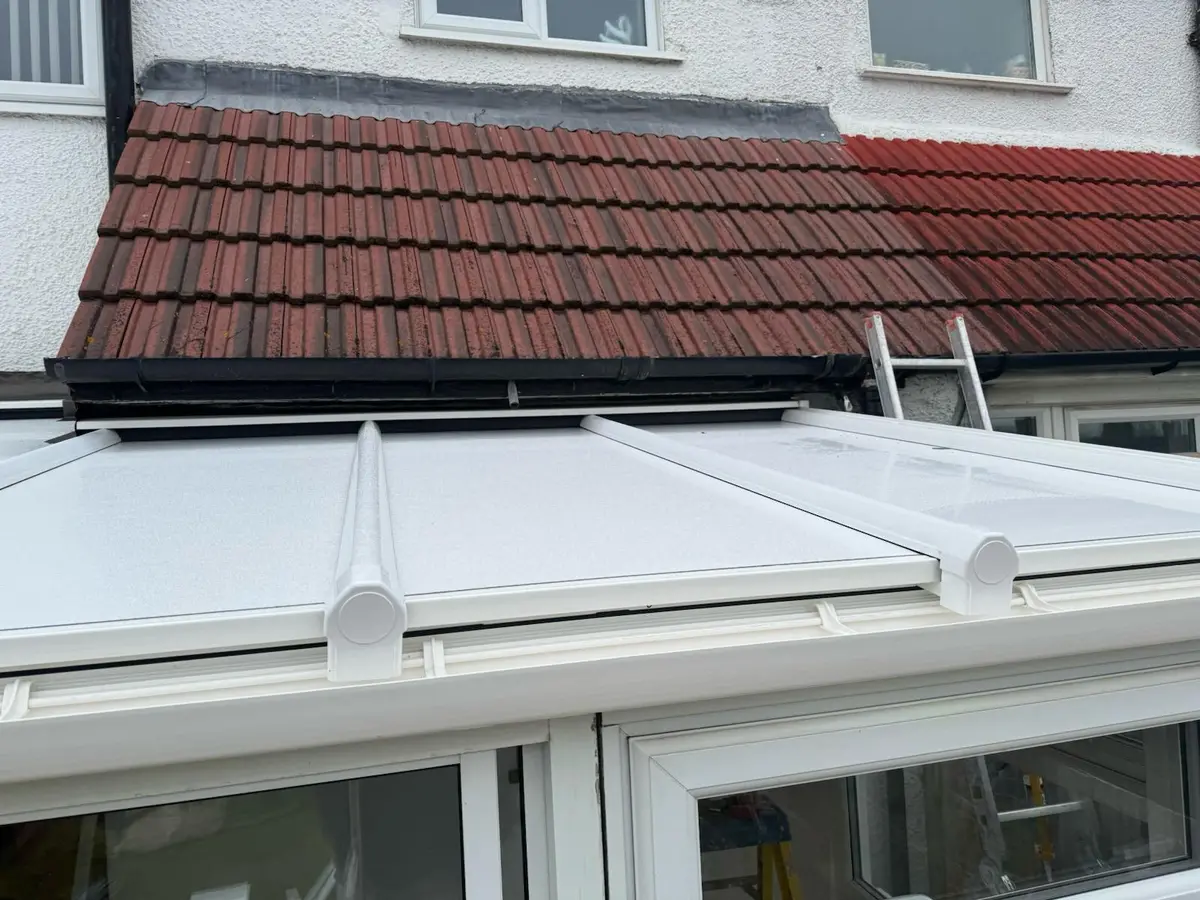 Close view of white roof panels and glazing bar caps on a finished lean-to conservatory