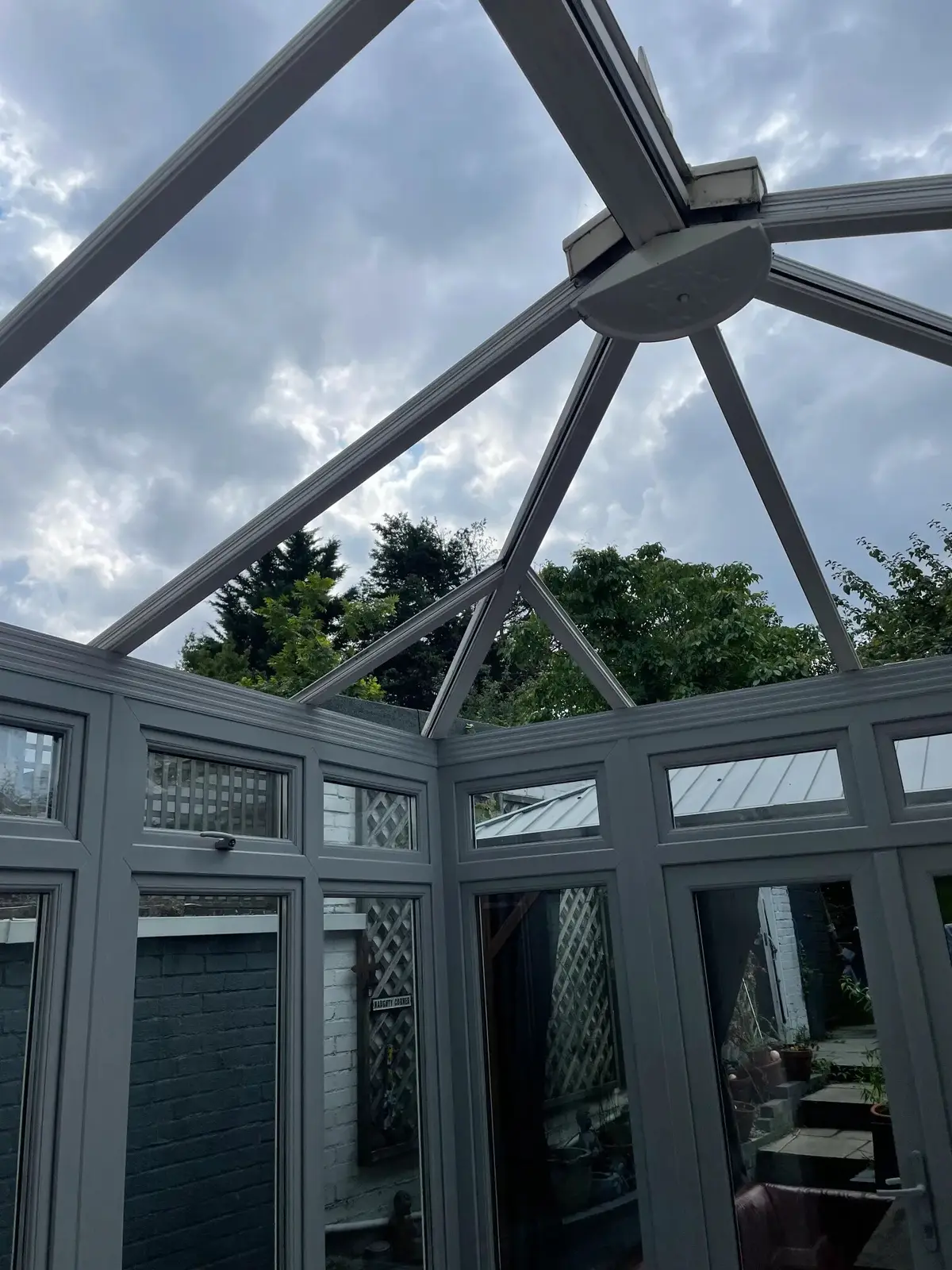Conservatory roof frame stripped back to the rafters with open sky above, ready for new insulated panels